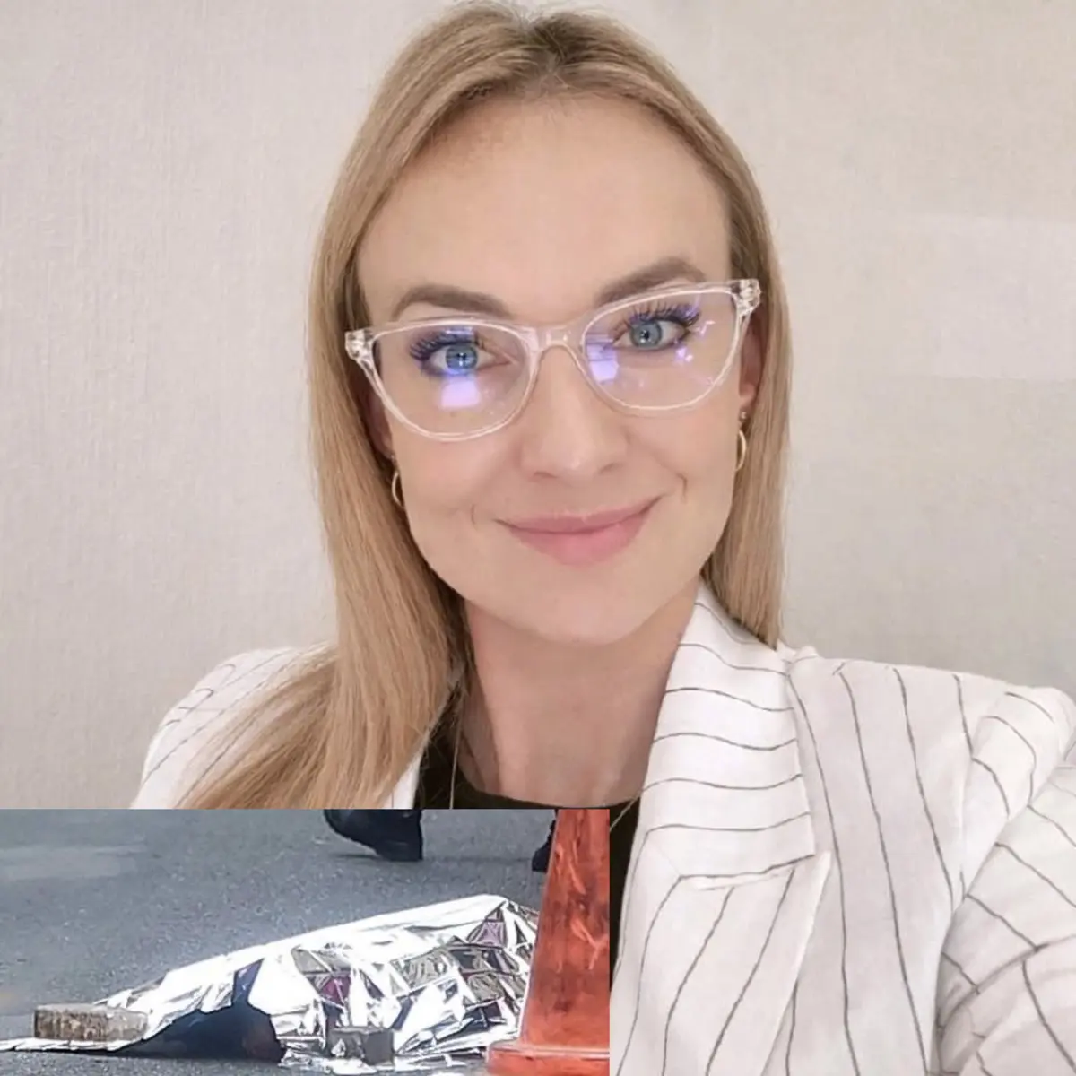 A woman with long blond hair and glasses smiles warmly, wearing a white striped blazer. Inset shows a reflective emergency blanket on the pavement.